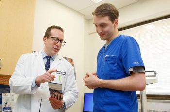 Dr Adam Friedman and colluegue are looking at a pamphlett